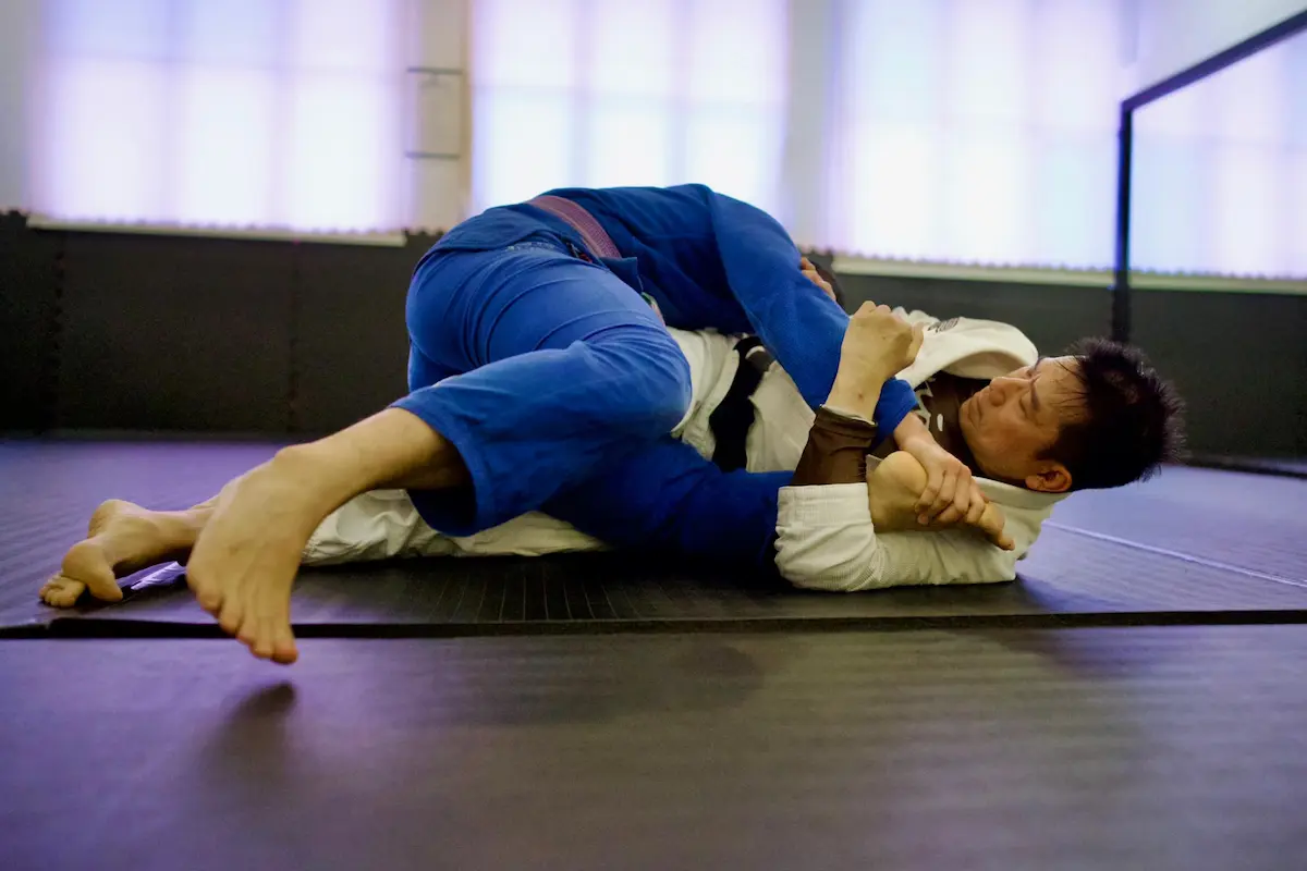 Coach Vince rolling with a student during BJJ training