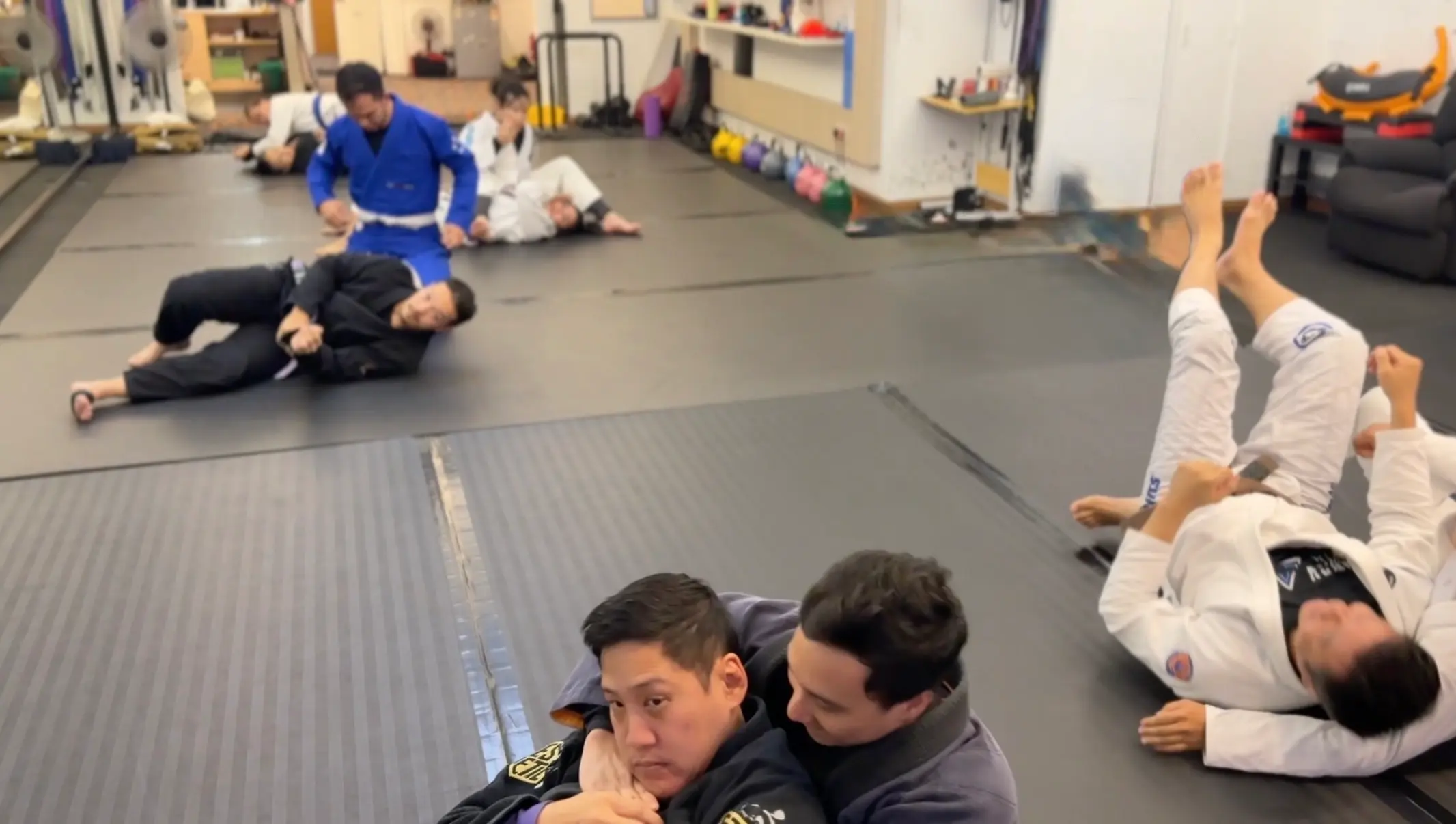 Training in progress at VCBJJ — multiple students rolling during class